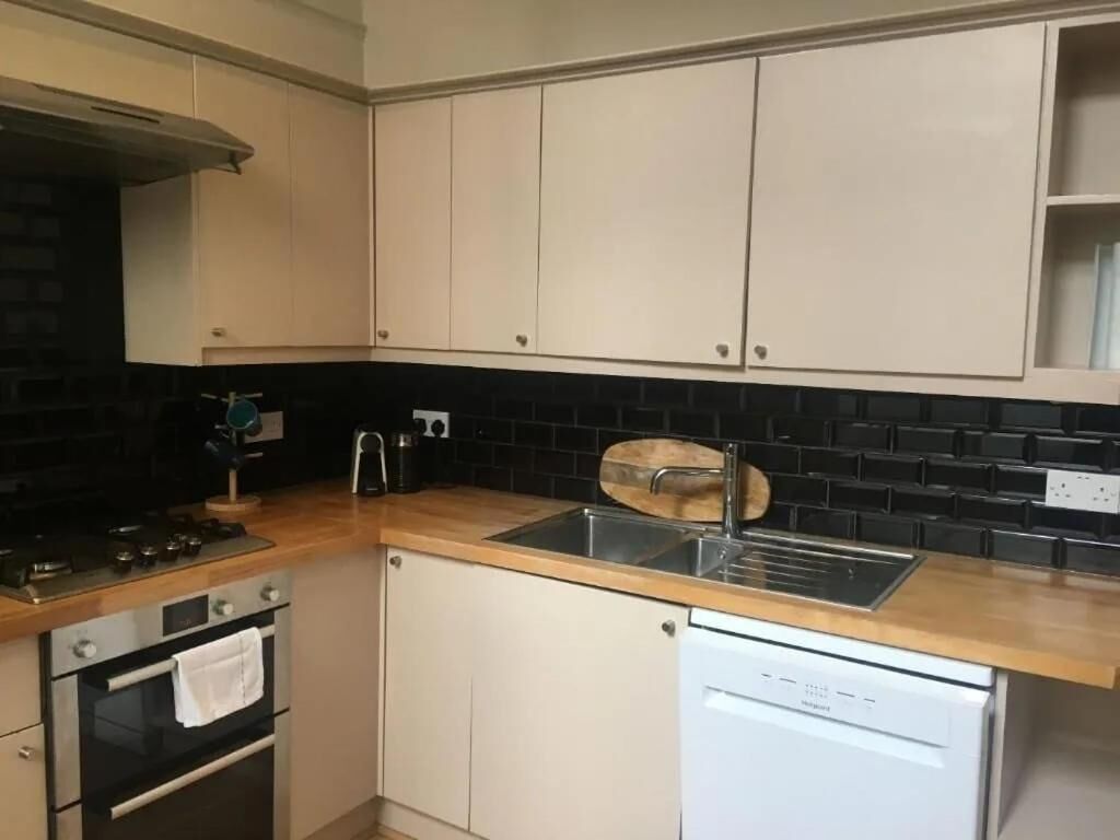 Una cocina equipada con estufa, horno, lavaplatos y fregadero.