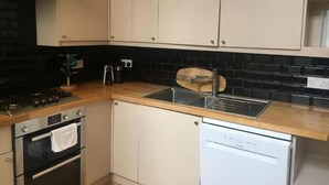 Eine Küche mit Herd, Backofen, Spüle und Geschirrspüler.