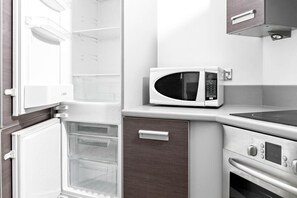 A kitchen with a microwave, oven, and refrigerator. - City Centre Apartment - Balcony - On Street Parking - Smart Tv & Neflix (Birmingham)