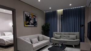 Un soggiorno moderno con un divano, un tavolino e una televisione.