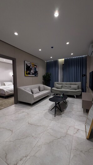 A modern living room with a sofa, a coffee table, and a TV. - 004 Tara-jre Jabal Al Lweibdeh With Stunning View (Amman)