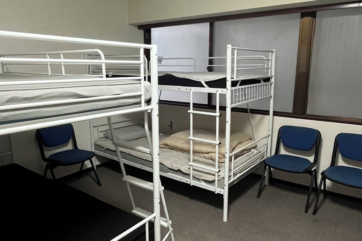 A bunk bed room with a desk and chairs.