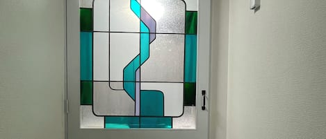 A hallway with a door featuring a geometric stained glass design.