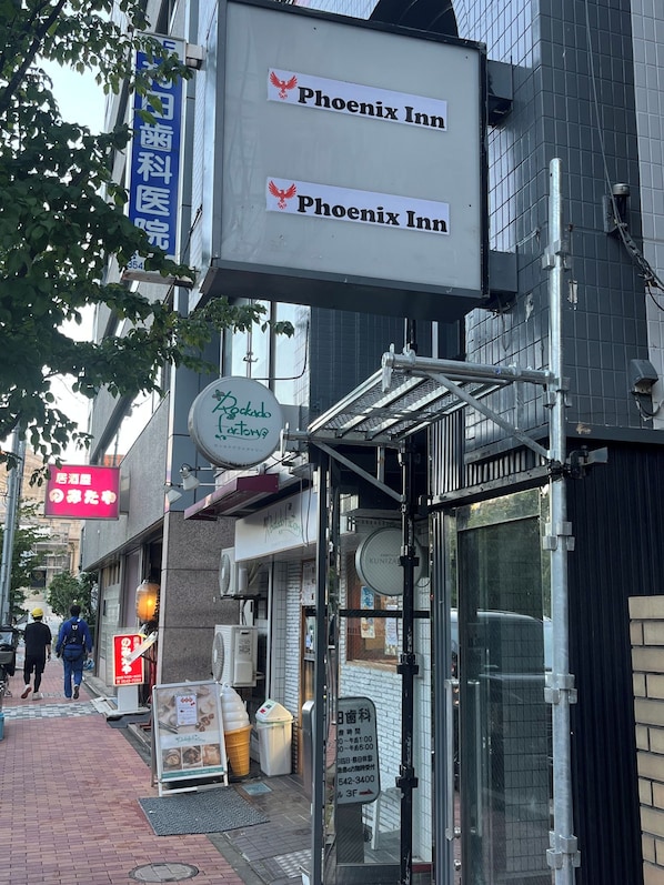 Une enseigne « Phoenix Inn » au-dessus de l’entrée d’un immeuble.