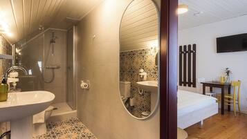 A modern bathroom with a shower, sink, and toilet.