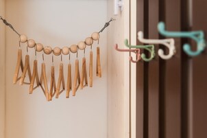 Un colgador de madera con varios tachones de madera y un hilo metálico.