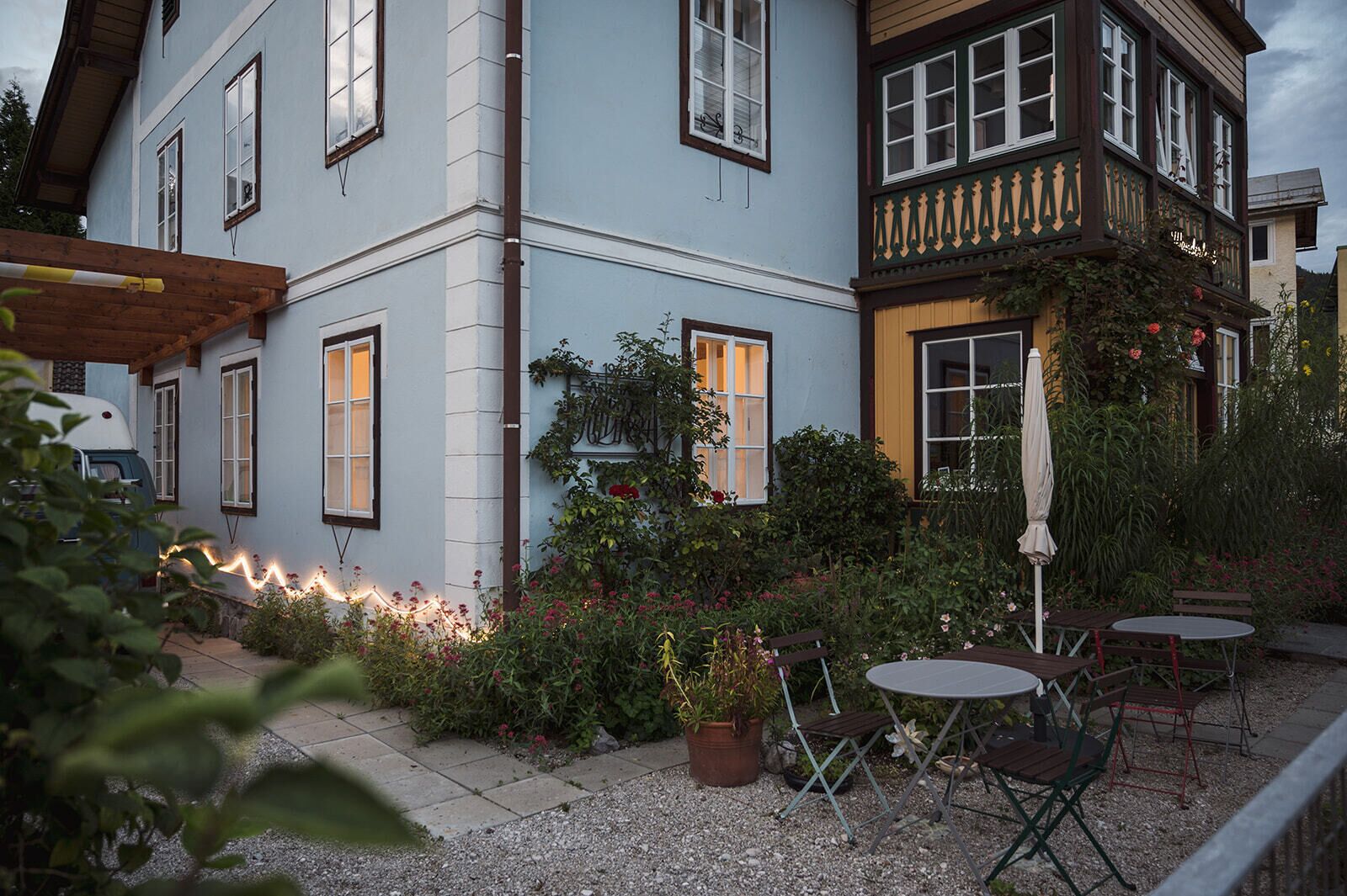 Un bâtiment à deux étages doté d’un balcon, d’un espace extérieur aménagé pour s’asseoir et d’un jardin.