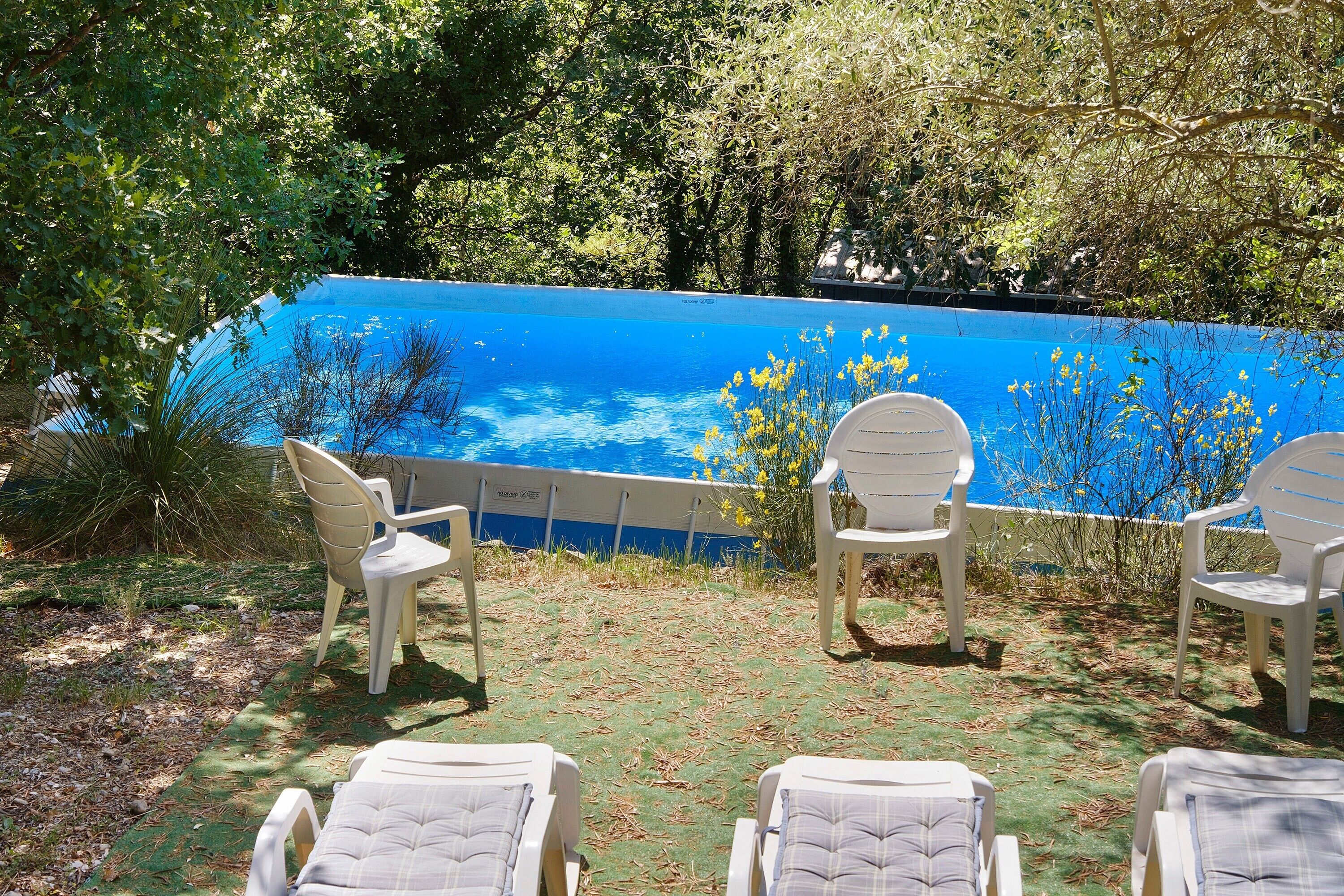 Un espace aménagé au bord de la piscine, avec des chaises longues et une piscine.