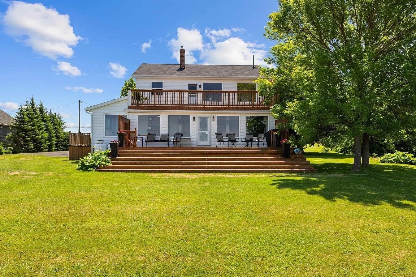 Une maison à deux étages dotée d’un balcon, d’un porche et d’une pelouse bien entretenue.