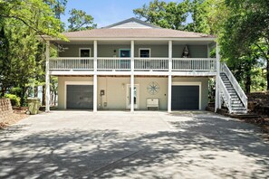 Une maison à deux étages avec un balcon, un garage et un escalier menant à l’étage supérieur.