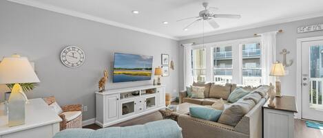 A living room with a sofa, TV, and decorative items.