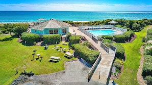 Um resort com piscina, terraço e vista para o oceano.