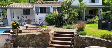 Une villa dotée d’une piscine, d’un espace extérieur aménagé et d’un mur en pierre.