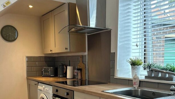 A modern kitchen with a built-in oven, microwave, and sink. - Herring House -Only  2 minute walk  from the beach front . (Spittal)
