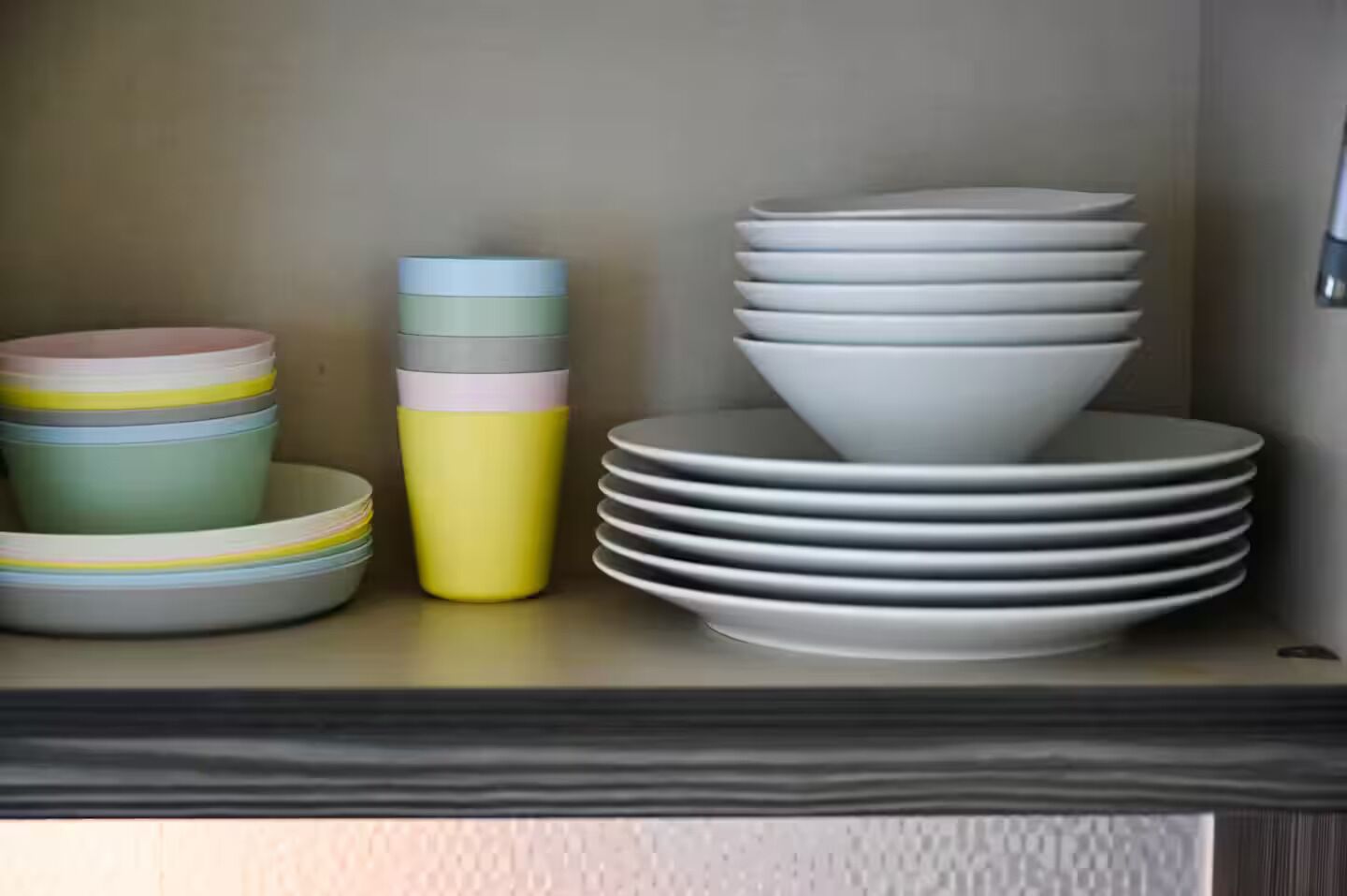A shelf with stacked plates and a cup.