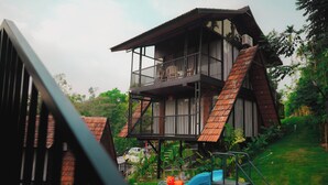 Een gebouw met twee verdiepingen, een balkon, een glijbaan en fitnessapparatuur.