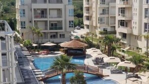 A multi-story hotel with a swimming pool, sun loungers, and a small gazebo. - Seaview Apartments (Orikum)
