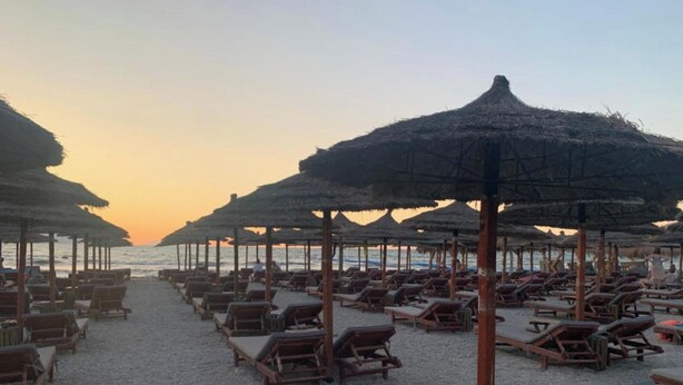 A beach with rows of sun loungers and thatched umbrellas. - Seaview Apartments (Orikum)