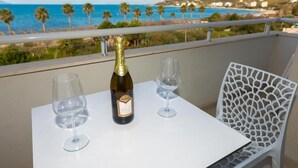 A balcony with a table, two wine glasses, and a bottle of wine. - Seaview Apartments (Orikum)