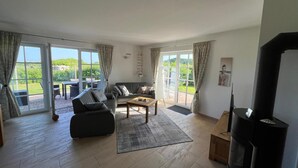 Ein geräumiges Wohnzimmer mit Sofa, Couchtisch und Kamin.