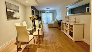 A modern living room with a dining area, a sofa, a coffee table, and a white cabinet. - Front line beach - sea view - terrace (Fuengirola)
