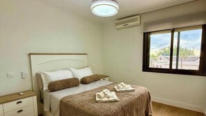 A bedroom with a bed, bedside tables, a window, and an air conditioning unit. - Front line beach - sea view - terrace (Fuengirola)
