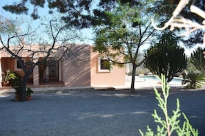 A building with a small pool, surrounded by gravel and potted plants. - Villa Miquela Charming house with ocean view (IB)