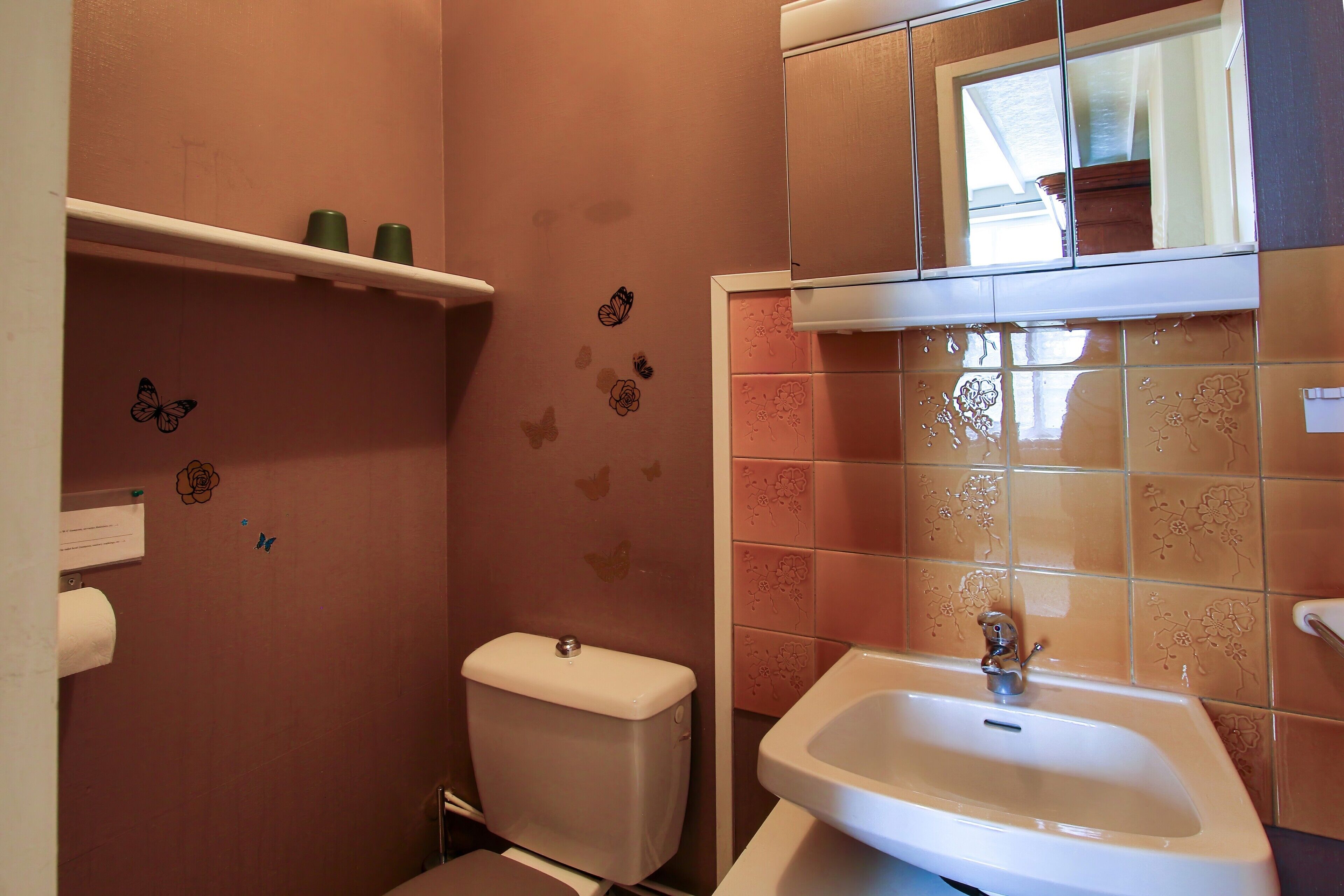 Une salle de bain équipée de toilettes, d’un lavabo et décorée d’autocollants muraux.