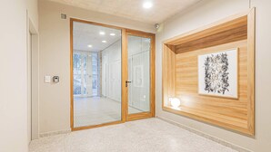A hallway with a wooden door, a framed abstract artwork, and a tiled floor. - Deluxe Apartment en Recoleta by Magno | 3A (Buenos Aires)