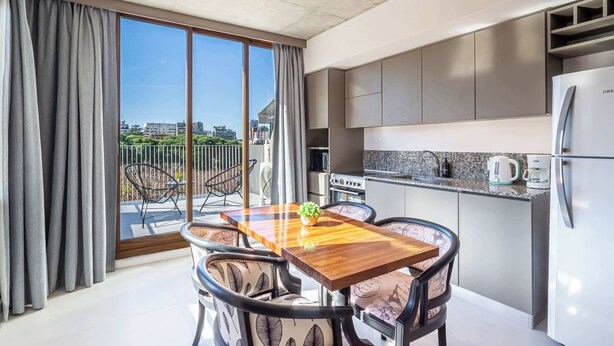 Une cuisine moderne avec un coin repas, de grandes fenêtres et une vue sur la ville.