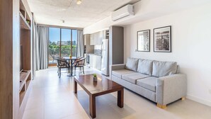 Un salon moderne comprenant un canapé, une table basse et un coin repas avec des chaises et une table.