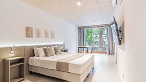 A modern bedroom with a large bed, bedside tables, a desk, and a balcony with a view. - Deluxe Apartment en Recoleta by Magno | 1A (Buenos Aires)