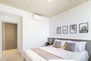 A bedroom with a bed, bedside tables, a wardrobe, and wall art. - Deluxe Apartment en Recoleta by Magno | 7A (Buenos Aires)