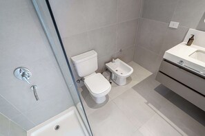 A modern bathroom with a toilet, bidet, and a sink. - Deluxe Apartment en Recoleta by Magno | 5A (Buenos Aires)