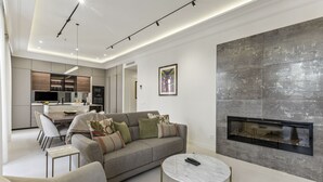 A modern living room with a sofa, coffee table, and fireplace. - Stylish 3BR Apartment in Madrid (Madrid)