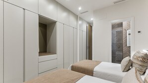 A bedroom with two beds, a walk-in closet, and a shower. - Stylish 3BR Apartment in Madrid (Madrid)