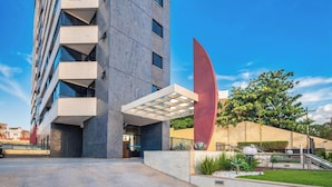 A modern building with a unique architectural design, featuring a prominent red structure and a glass-covered entrance. - Apt in Condo w/ Pool 300m From the Beach Hor0285 (Salvador)