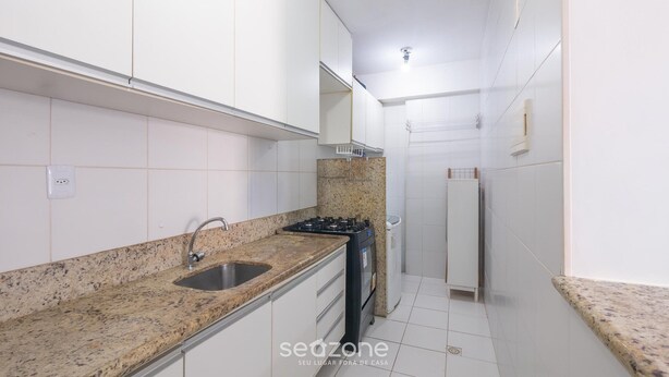 A kitchen with white cabinets, a granite countertop, a sink, a stove, and a trash bin. - Apt in Condo w/ Pool 300m From the Beach Hor0285 (Salvador)