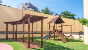 A playground with wooden structures, a slide, and a climbing area. - Apt in Condo w/ Pool 300m From the Beach Hor0285 (Salvador)