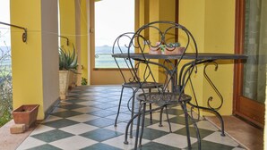 Ein Balkon mit kariertem Boden, gelben Wänden und einem Tisch mit Stühlen.