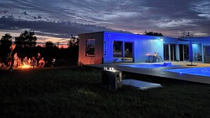 A modern house with a pool, a fire pit, and a clear sky. - Domek nr 1 "błękitne Wzgórze" (gmina Brzuze)
