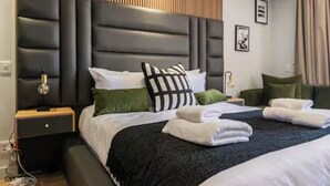 Una habitació d'hotel moderna amb un llit gran, una tauleta de nit, un aparell d'aire condicionat i una làmpada de paret.