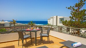 Une terrasse avec une table préparée pour le petit-déjeuner, donnant sur l’océan.