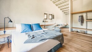 A modern bedroom with a large bed, a desk, and a built-in wardrobe. - Villa Cervia - Six Bedroom Villa, Sleeps 15 (Cervià de Ter)