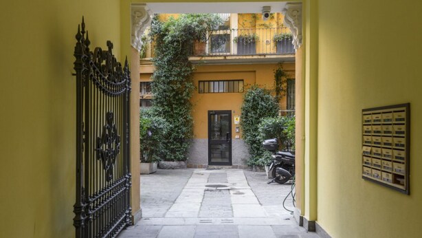 A courtyard with a wrought iron gate, a door, and a wall-mounted mailbox. - Marcona, 1 - Quiet two-room Milanese apartment (Milan)