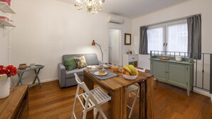 A compact living space with a dining area, a sofa, a small table with a bowl of fruit, and a kitchenette. - Marcona, 1 - Quiet two-room Milanese apartment (Milan)