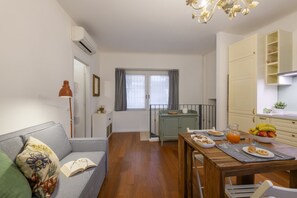 Ein kompakter Wohnbereich mit Sofa, Esstisch und Küchenzeile.