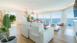 A modern living room with a white sofa, a coffee table, and a view of the ocean. - Luxury Villa Sea Views 6 rooms 12 pax wifi air conditioning (LLucmajor)