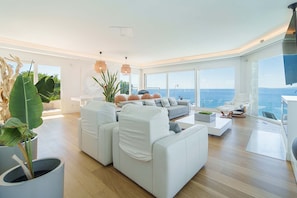 A modern living room with a white sofa, a coffee table, and a view of the ocean. - Luxury Villa Sea Views 6 rooms 12 pax wifi air conditioning (LLucmajor)