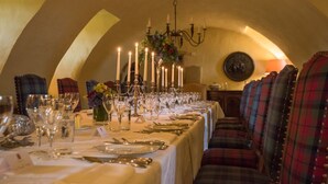 A long dining table set with candles, glassware, and cutlery, with plaid upholstery and a chandelier. - Fenton Tower - Six Bedroom Villa, Sleeps 12 (Kingston)